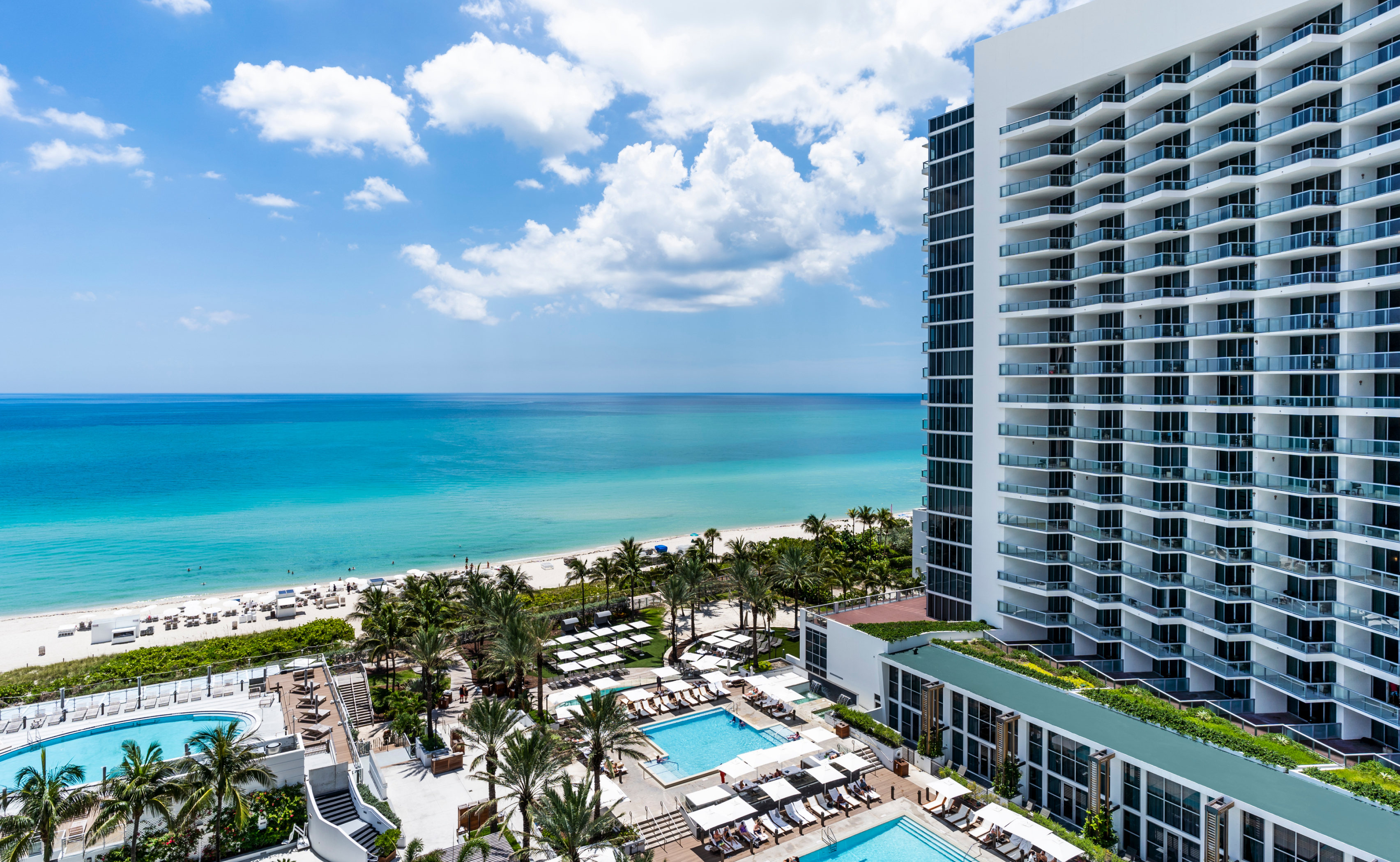 An aerial view of a beachfront resort with a pool and ocean view.